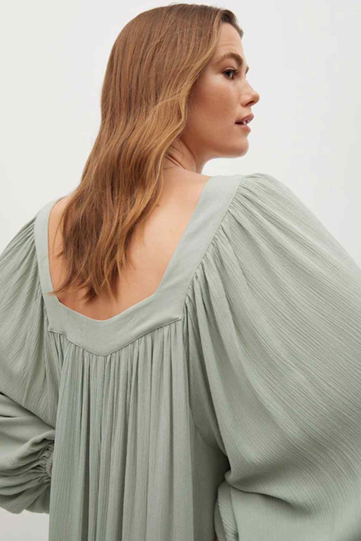 Pastel green back yoke with pleats and long balloon sleeves on a midi dress
