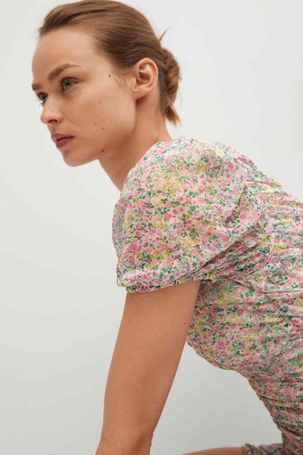 Pastel pink floral mini dress side view with short puff sleeve and fitted skirt