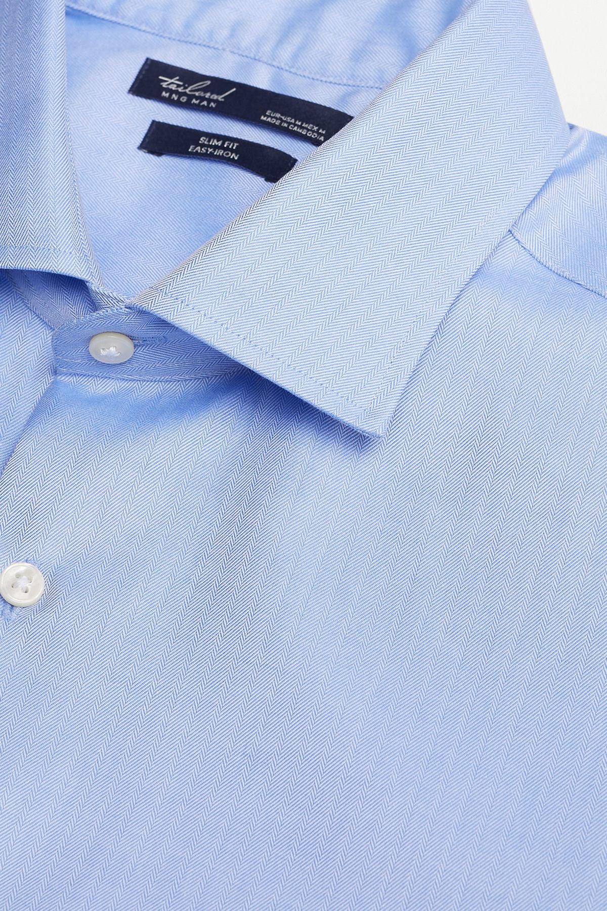 Sky blue button-up shirt collar close-up with white buttons and stitched placket
