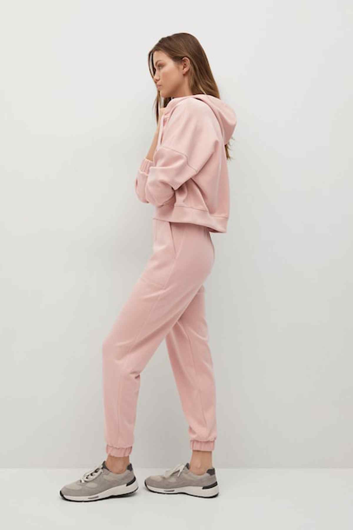 Pastel pink jogger pants with elastic waist, side seams, and ankle cuffs
