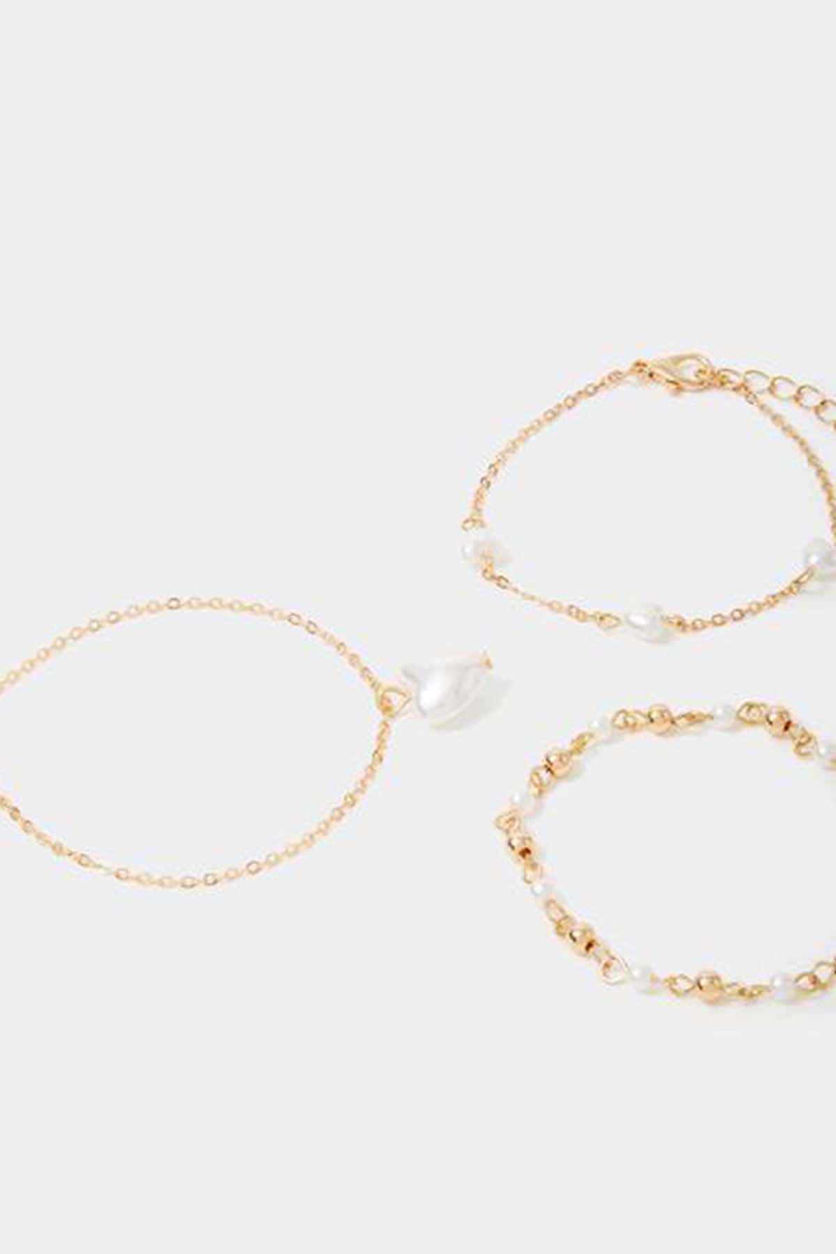 Three gold-tone pearl charm bracelets, heart pendant and bead link details