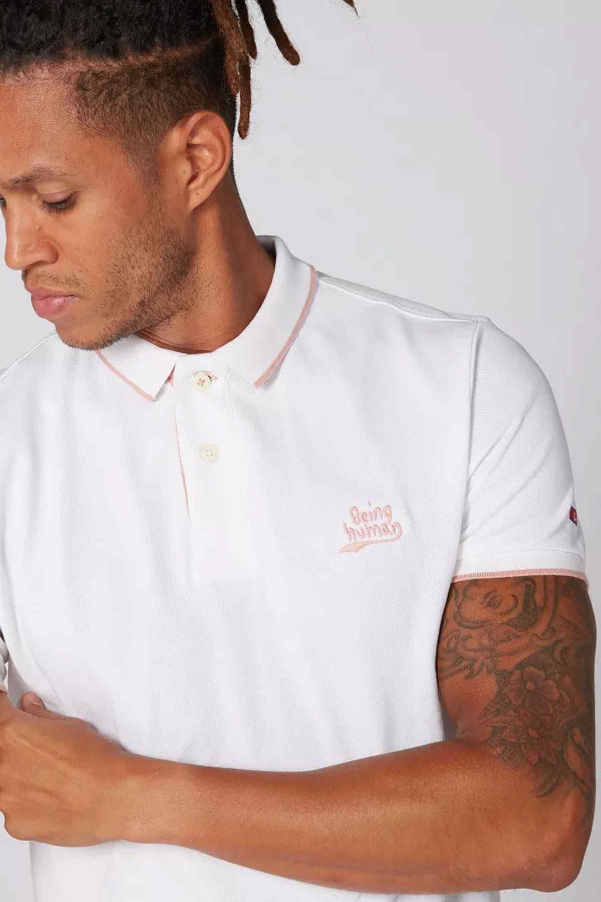 White polo shirt with buttoned collar and chest logo detail, short sleeves
