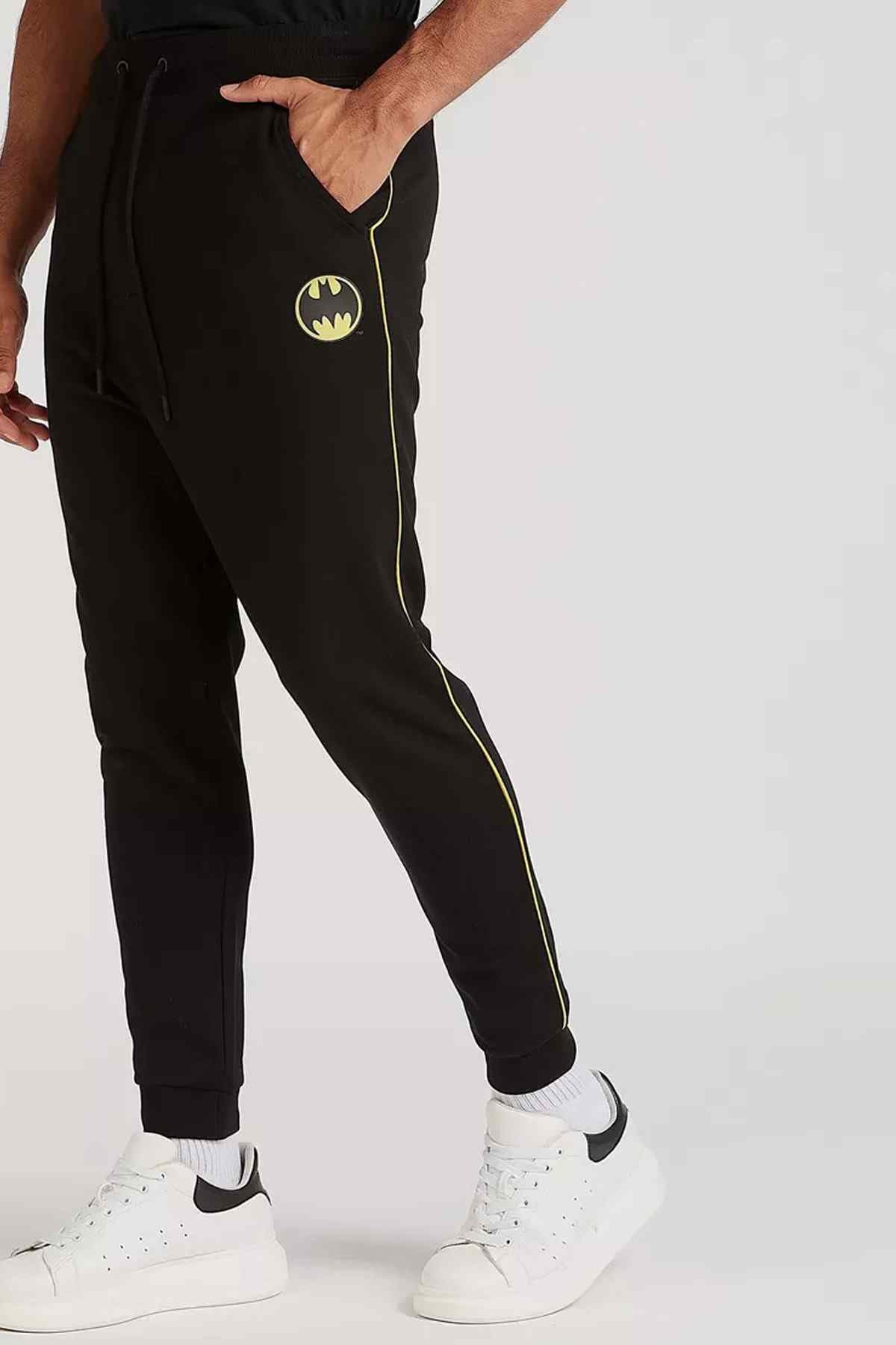 Black jogger pants with yellow side stripe and bat emblem, slim tapered leg