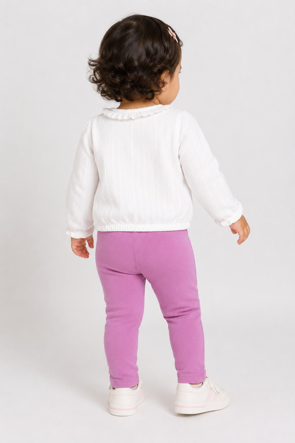 Baby outfit: white long-sleeve ruffle blouse with purple leggings, rear view