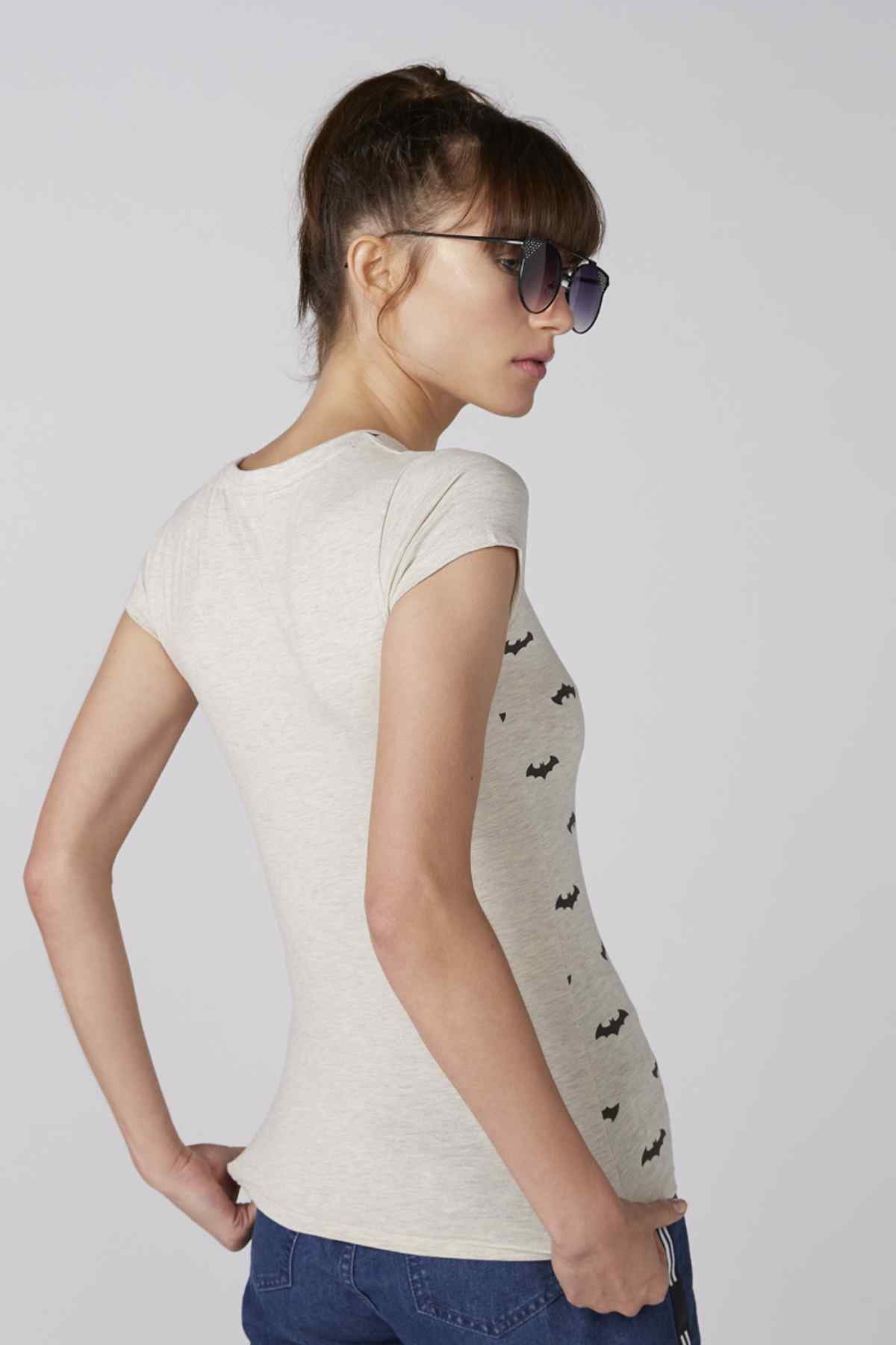 Light beige short-sleeve T-shirt, side view, small black mustache pattern