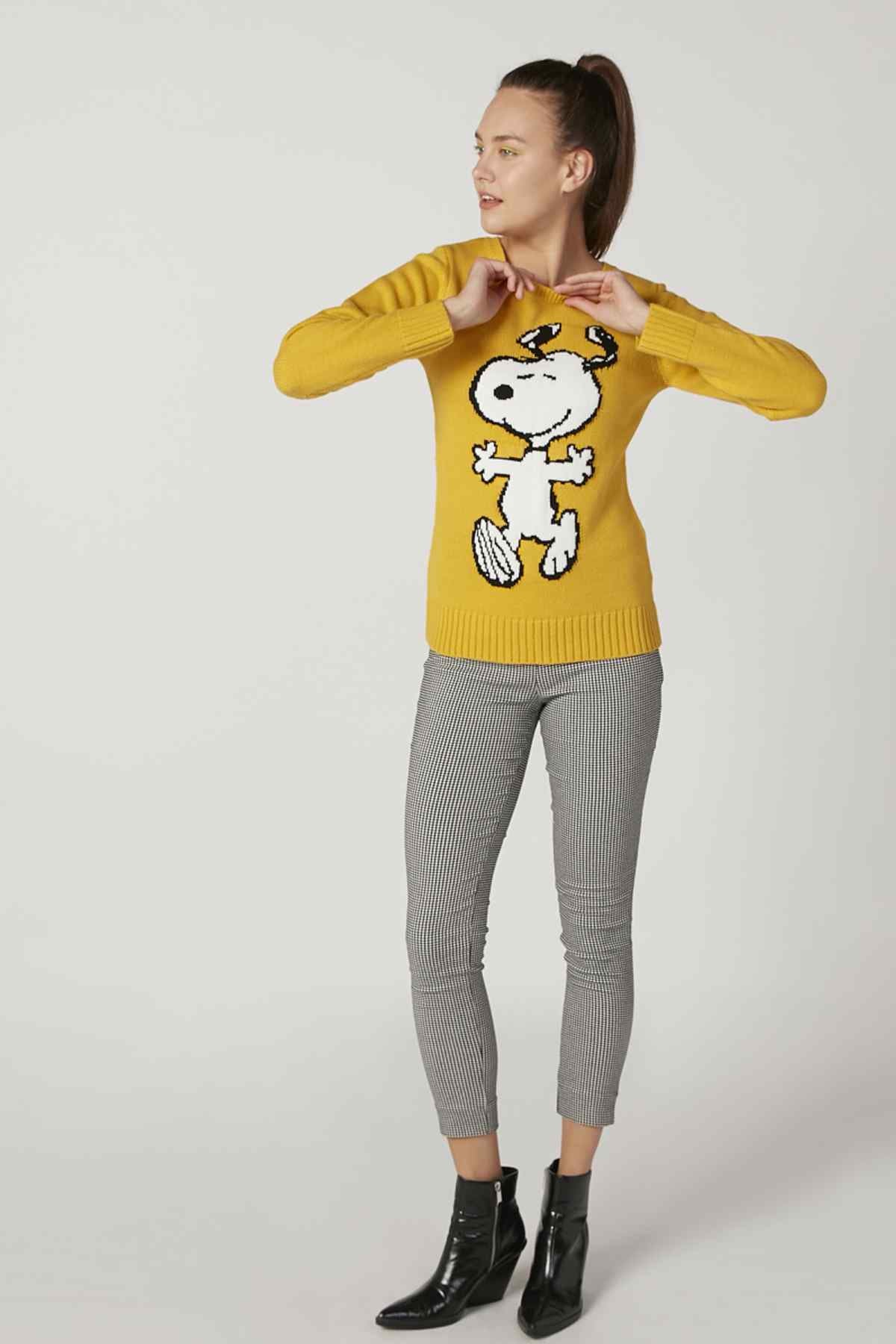 Yellow knit sweater with full cartoon dog graphic, crew neck, long sleeves; paired with gray pants.