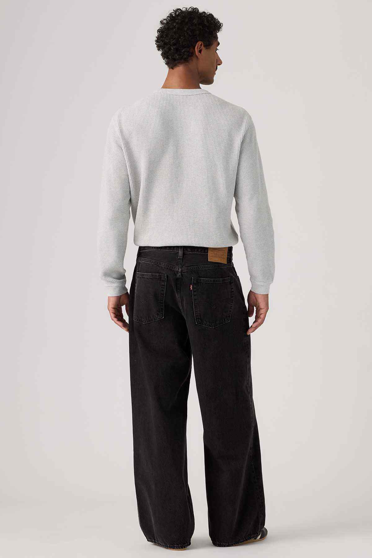 Black denim jeans back view with wide straight legs and rear yoke stitching