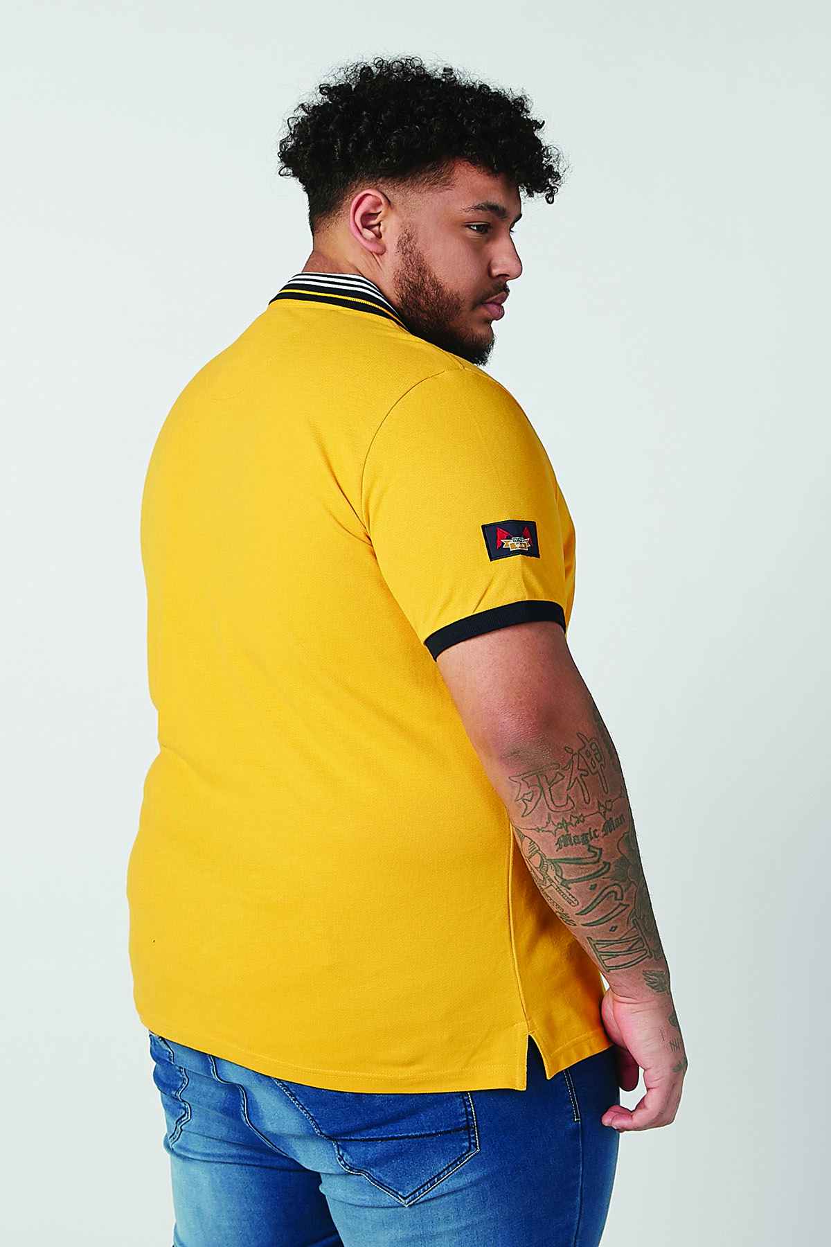 Men's yellow polo shirt with striped collar and dark sleeve cuffs