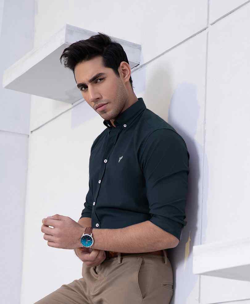 Dark green fitted button-up shirt with long sleeves and small chest logo