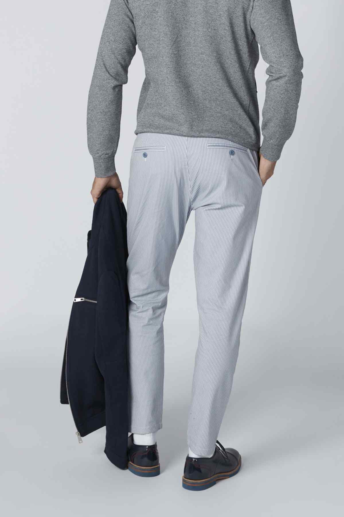 Men's heather gray long-sleeve top with light blue trousers, belt loops