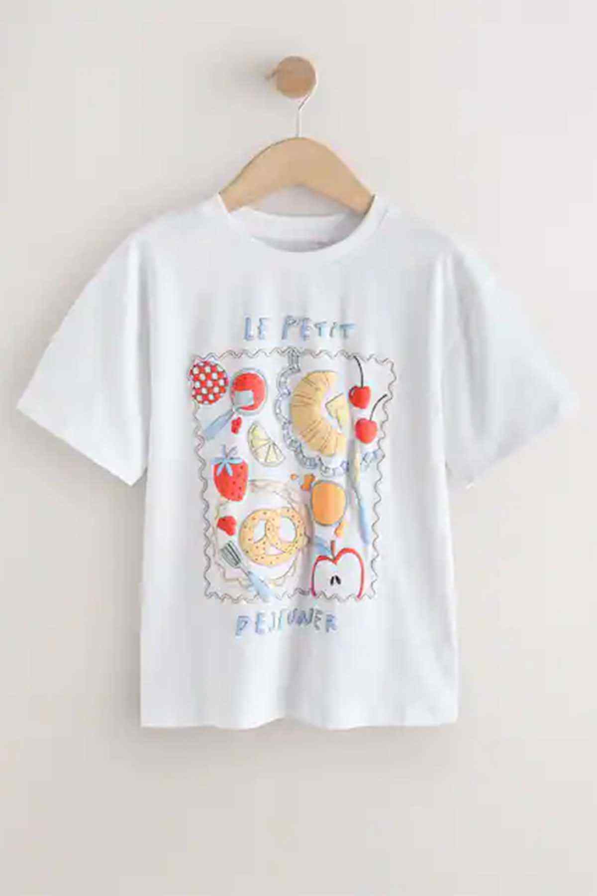 White kids graphic T-shirt on wooden hanger with dessert patchwork front print