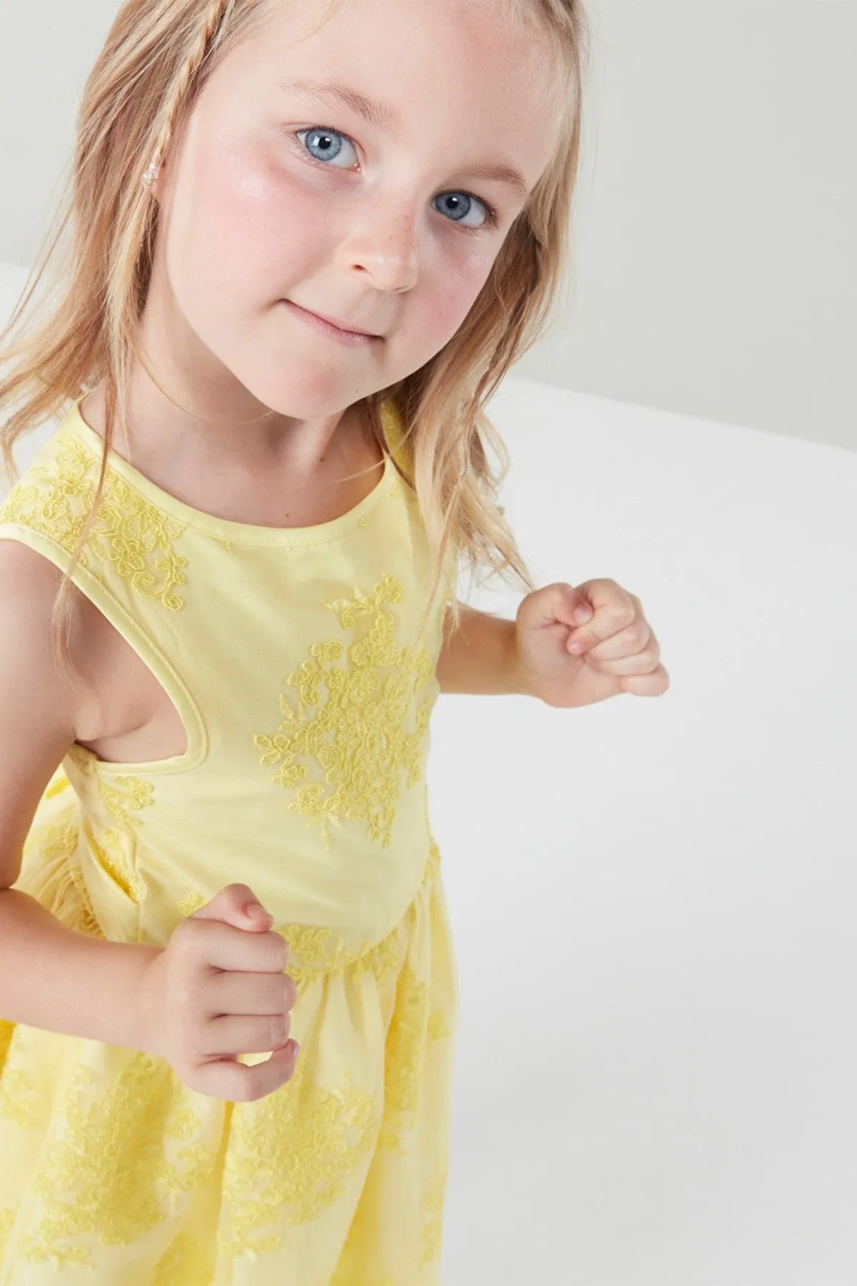Yellow sleeveless toddler dress close-up with floral embroidery and round neckline