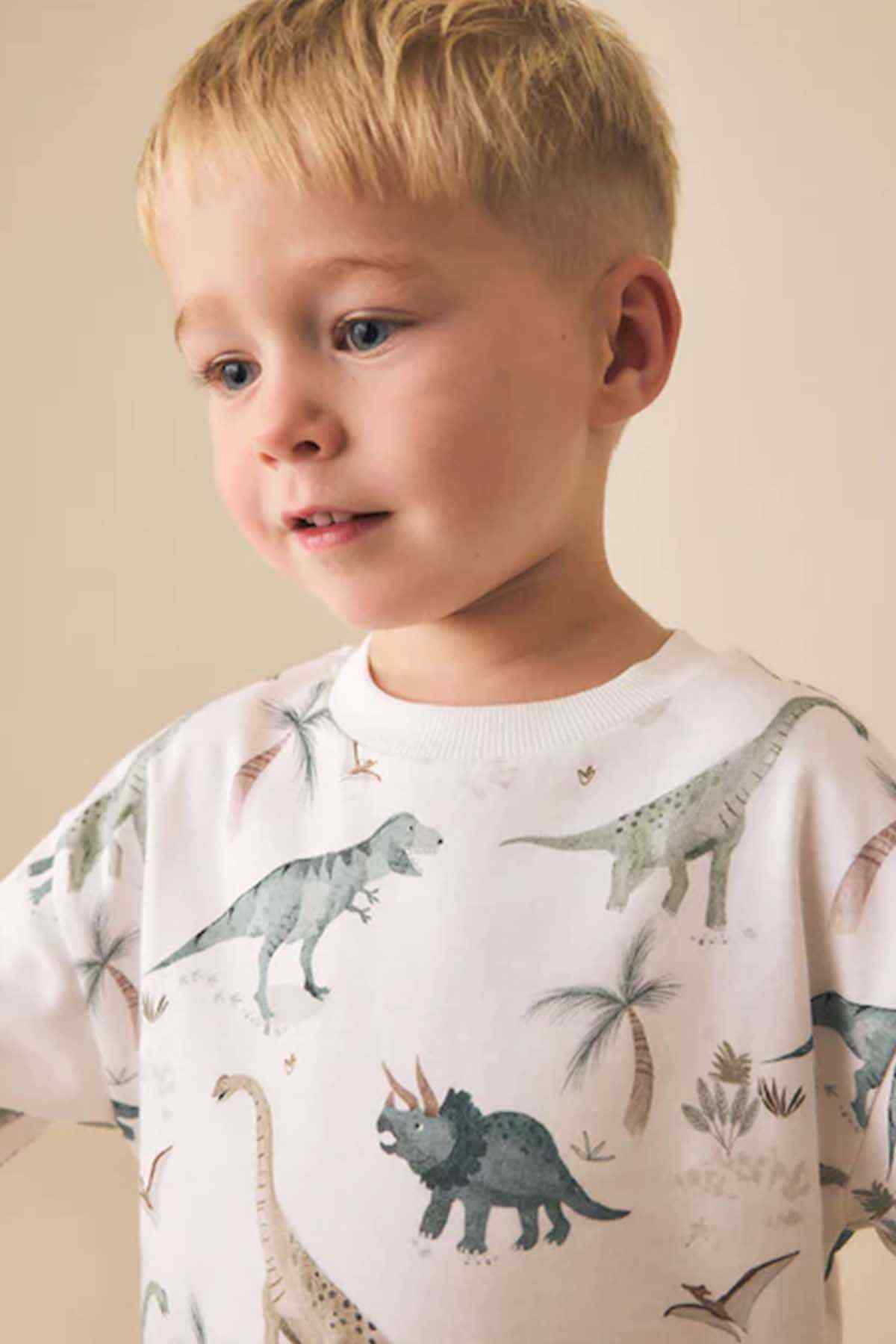 Kids white dinosaur print T-shirt close-up with crew neck and short sleeves