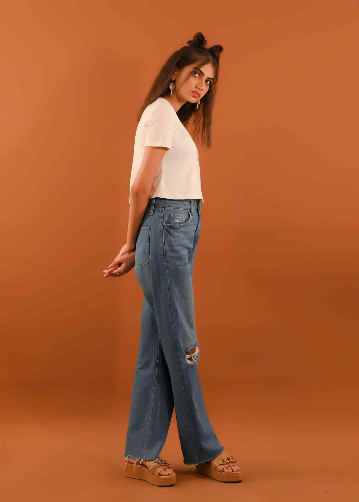 White short-sleeve crop top and relaxed-fit light blue jeans with knee rips