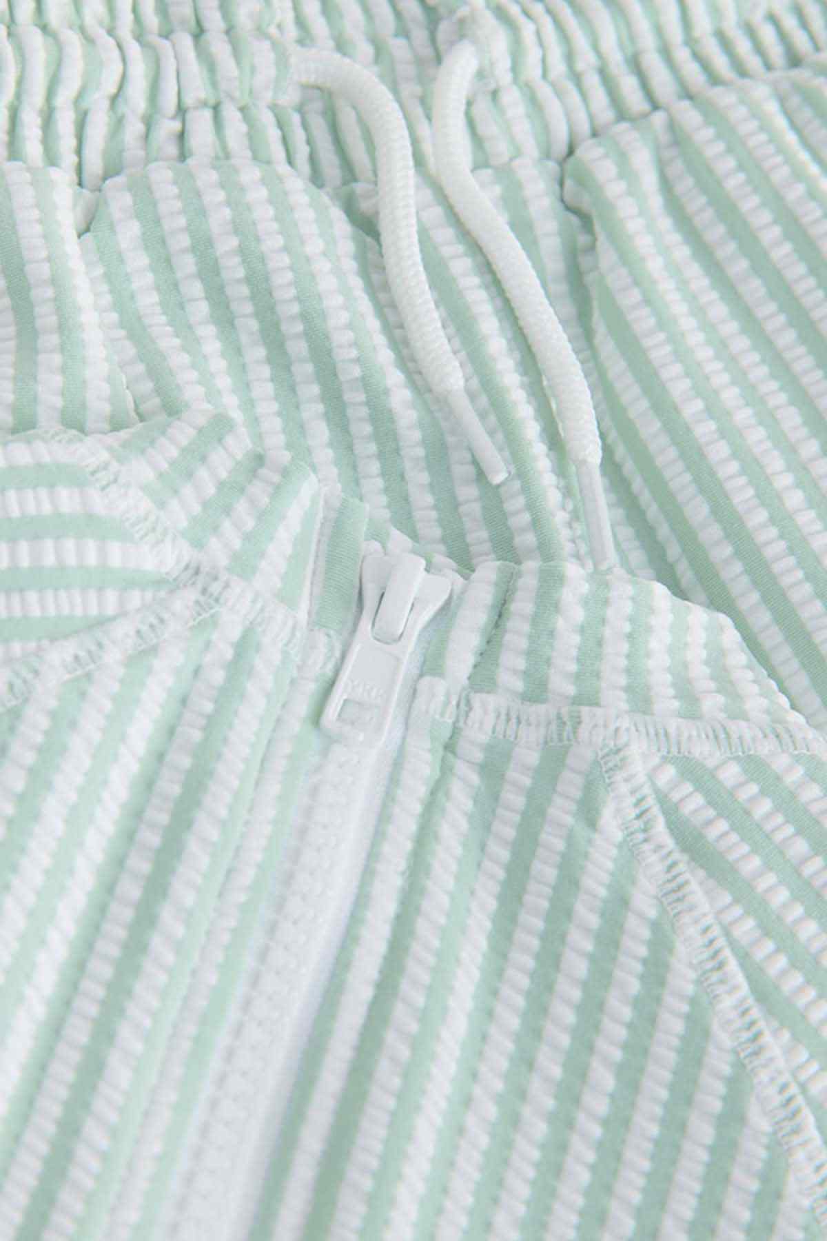 Green and white striped knit top with button placket and gathered neckline