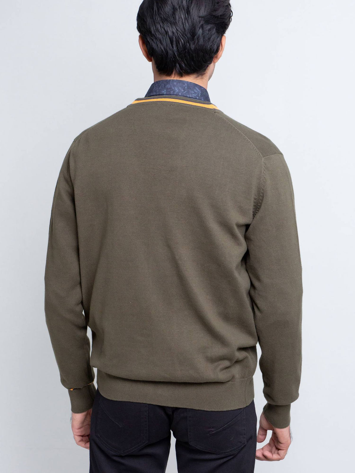 Olive green cardigan back view with orange-trim yoke and ribbed cuffs