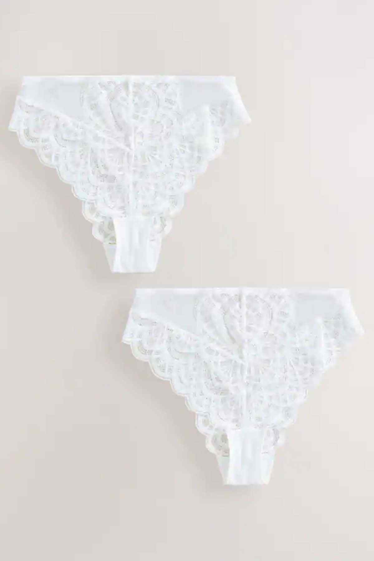 Two white lace thong designs with scalloped ruffle trim