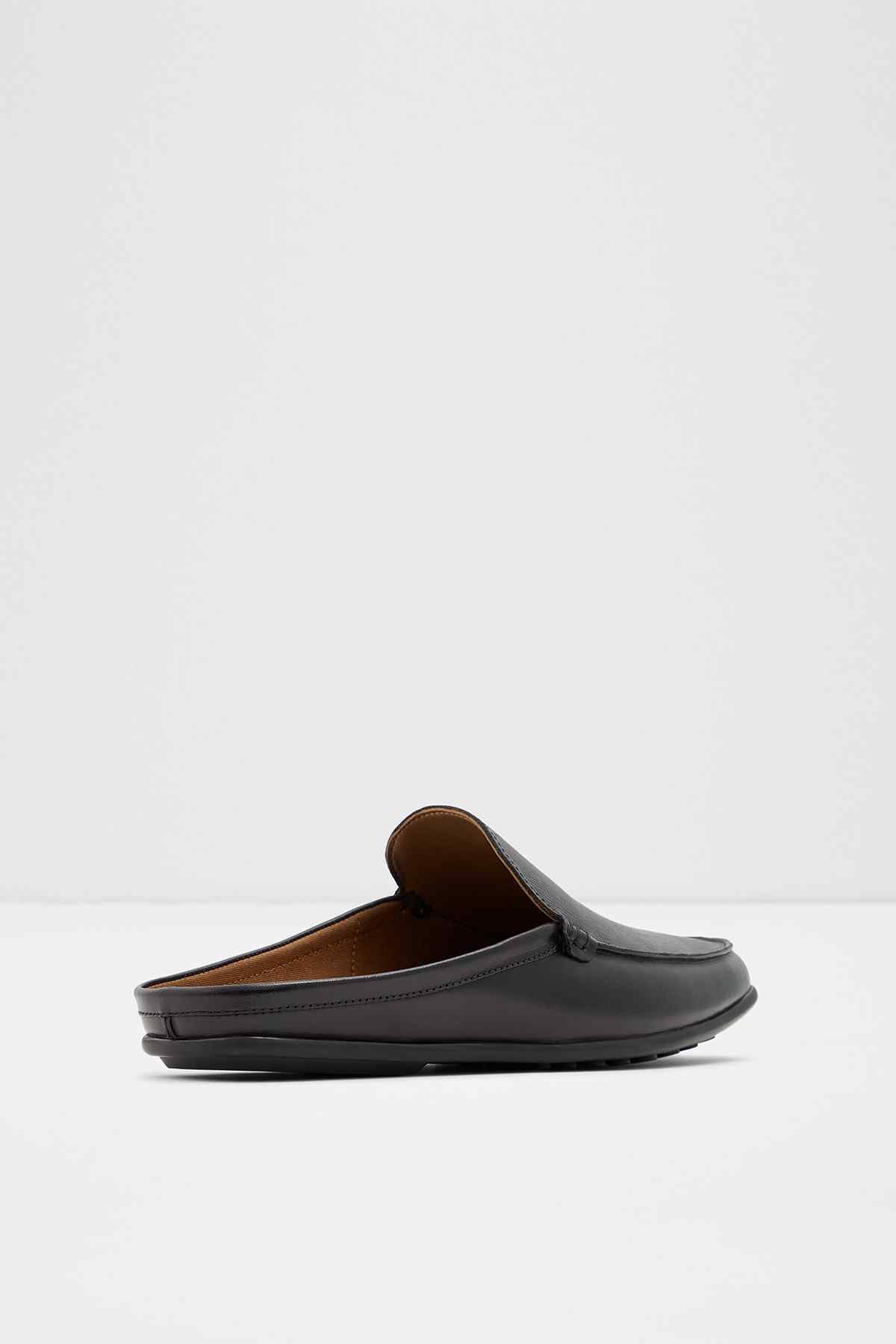 Black slip-on loafer with tan lining visible at opening, angled view