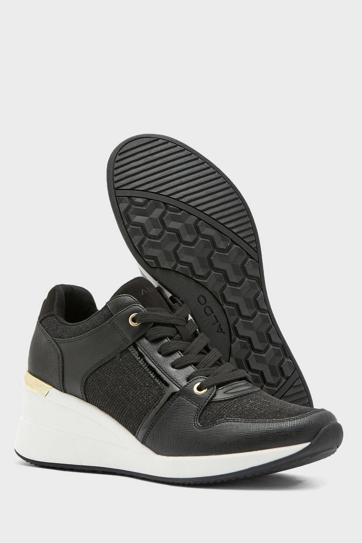 Black low-top sneakers with textured tread sole and knit side panels