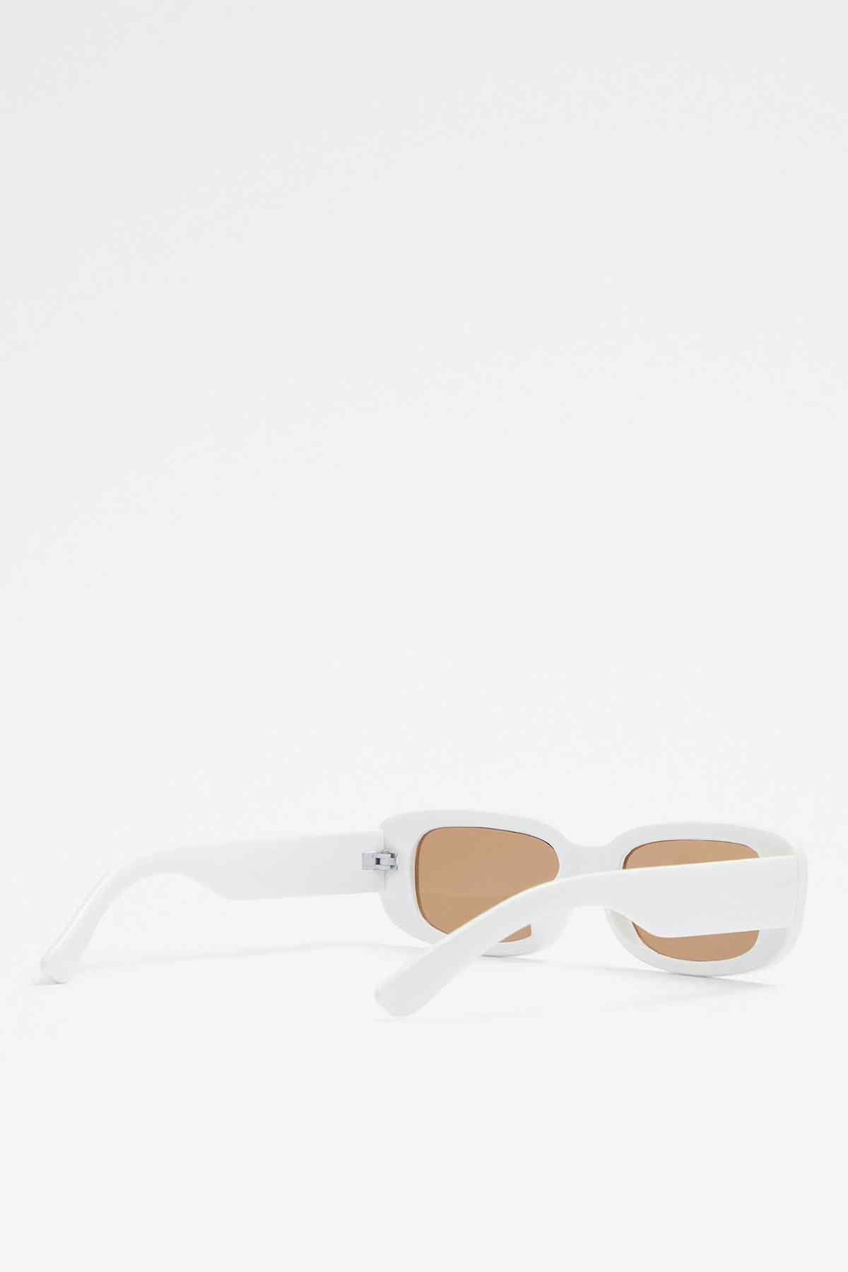 White sunglasses with tan lenses and visible side arm, low profile