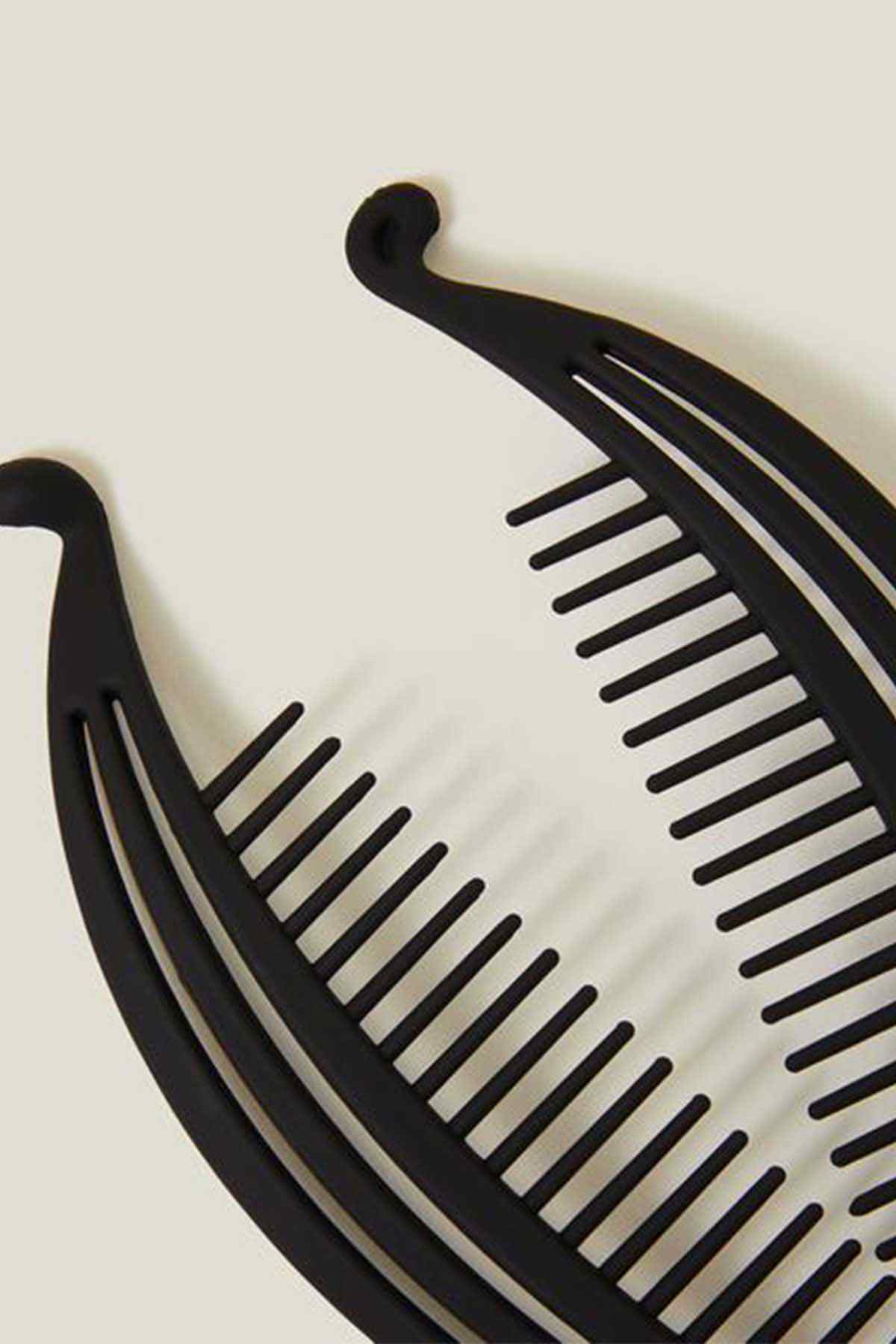 Black curved hair comb close-up with evenly spaced ridged teeth