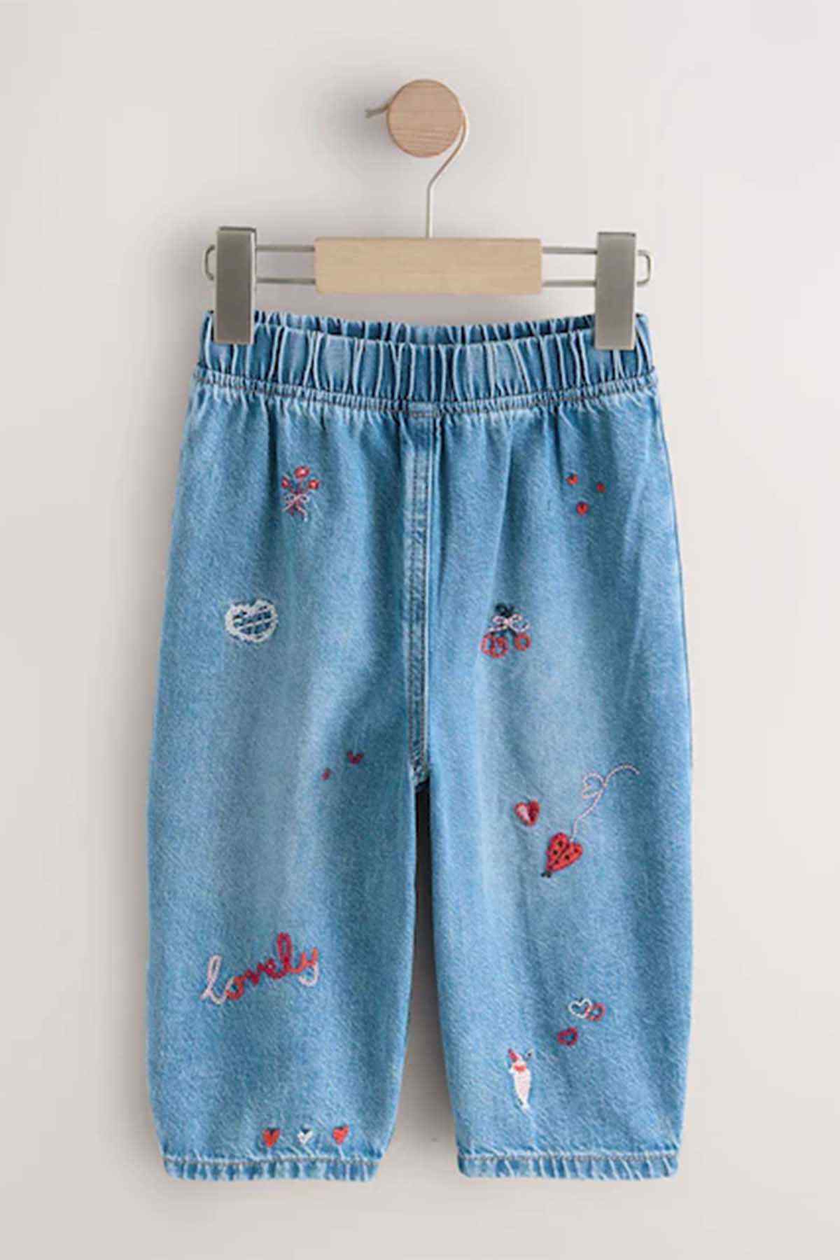 Blue embroidered denim pants on hanger, elastic waistband and wide leg