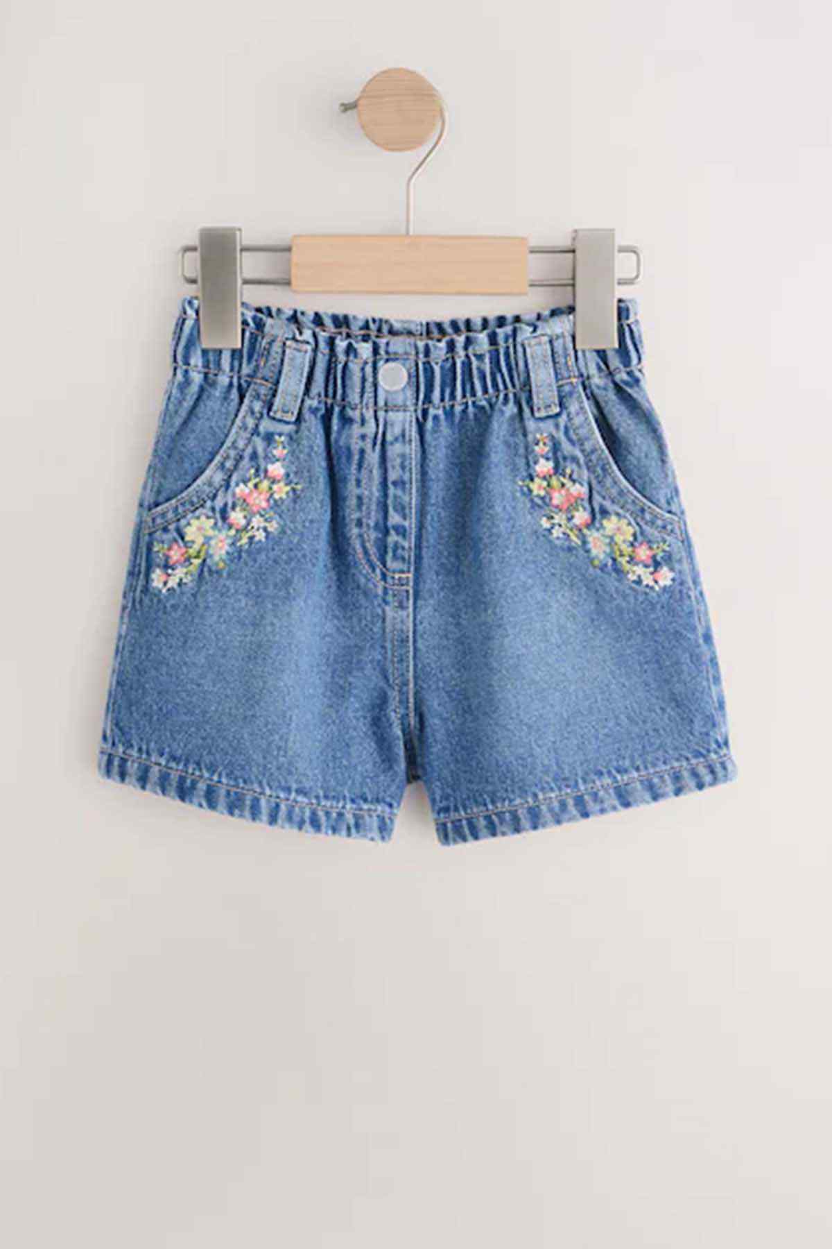Girls' blue denim shorts with floral embroidery and elastic waistband.
