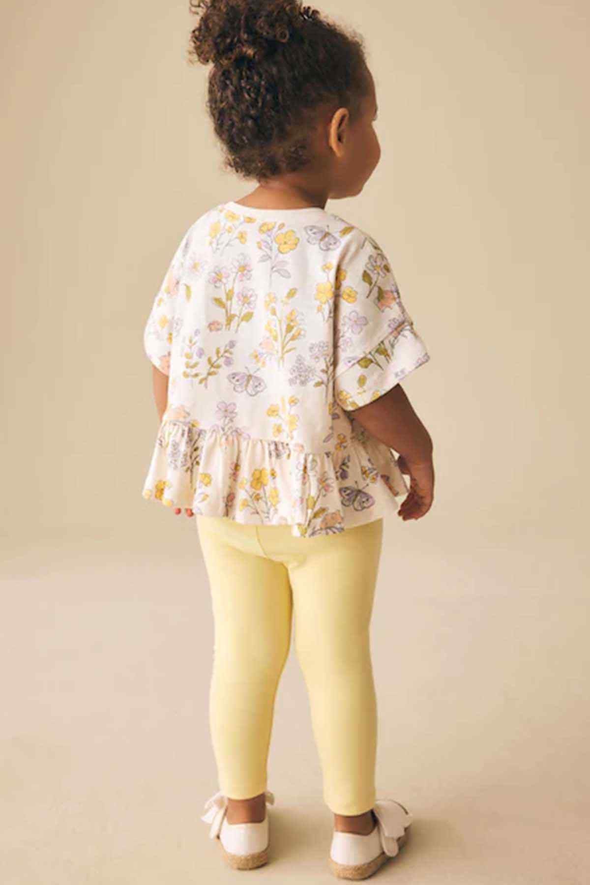 Girls' floral peplum top, back view with short sleeves and gathered hem