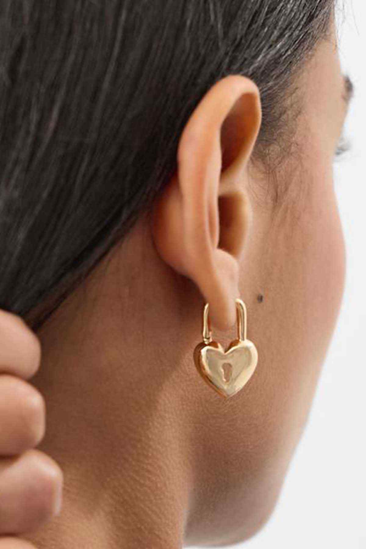 Gold heart drop hoop earrings on ear, small open-heart charm