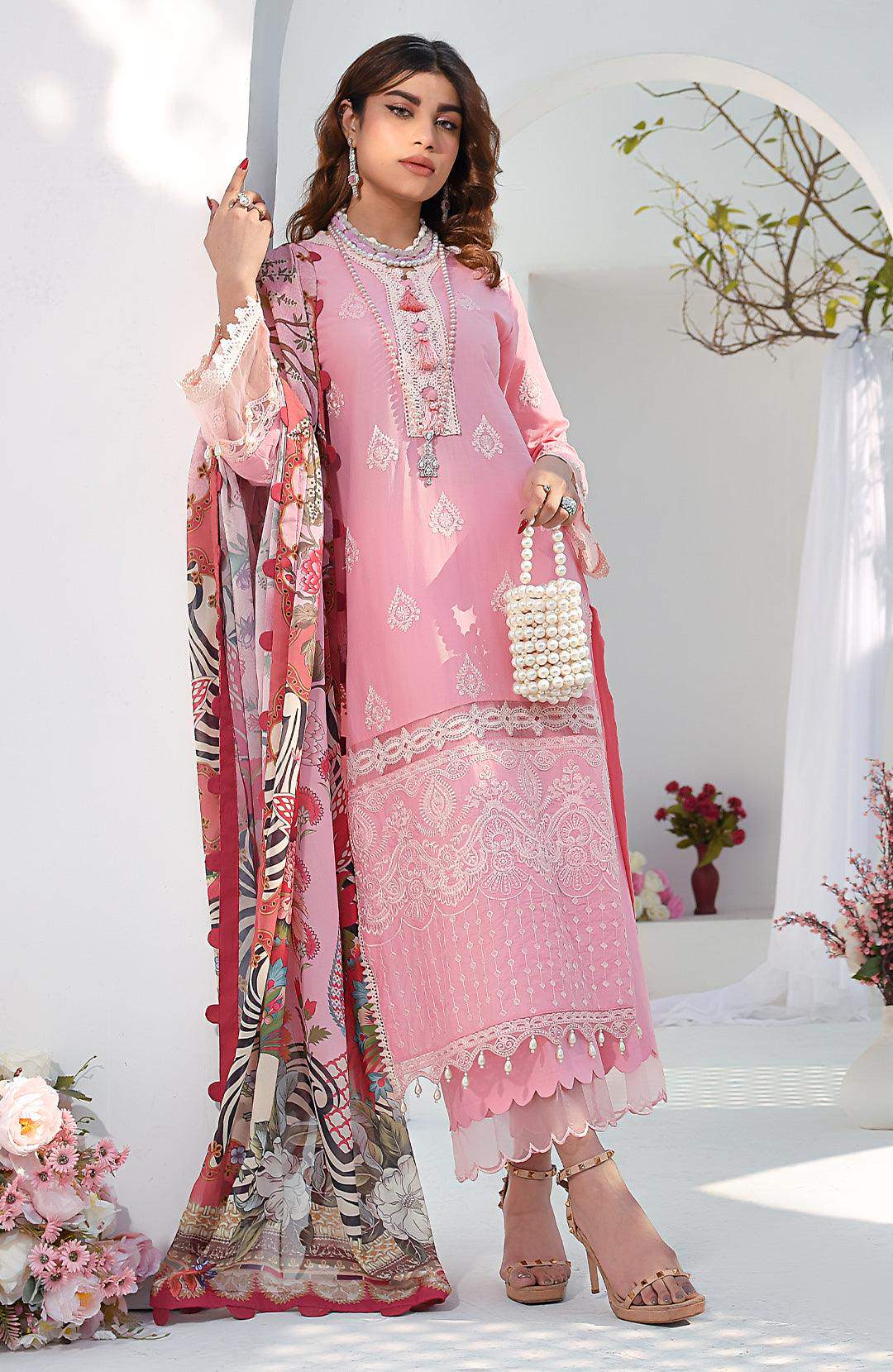 Rose pink embroidered dress with scalloped hem and pearl bracelet, holding pearl handbag