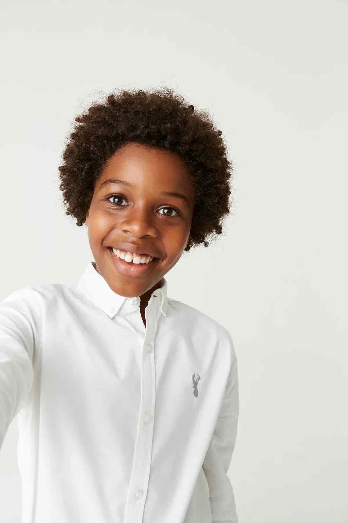White button-up shirt close-up with pointed collar and small embroidered logo at chest