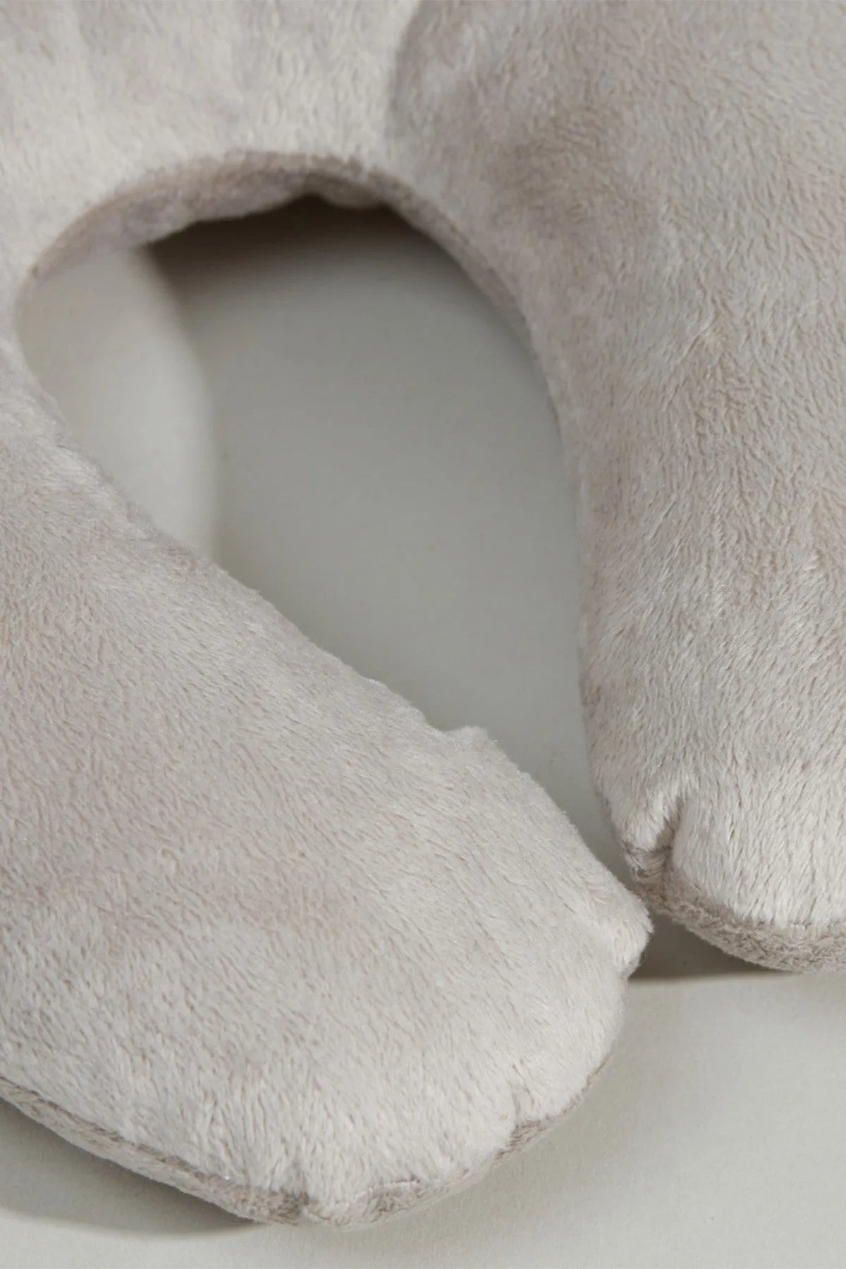 Close-up of light grey U-shaped baby neck pillow plush fabric