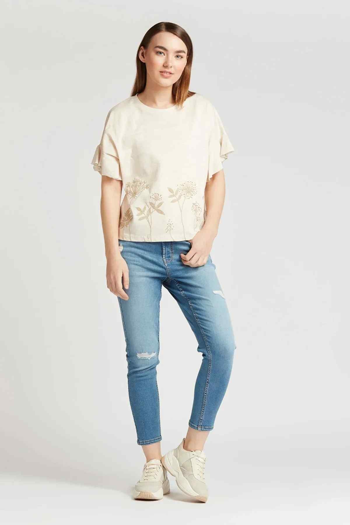 Light blue cropped distressed jeans with ripped knee details and rolled cuffs
