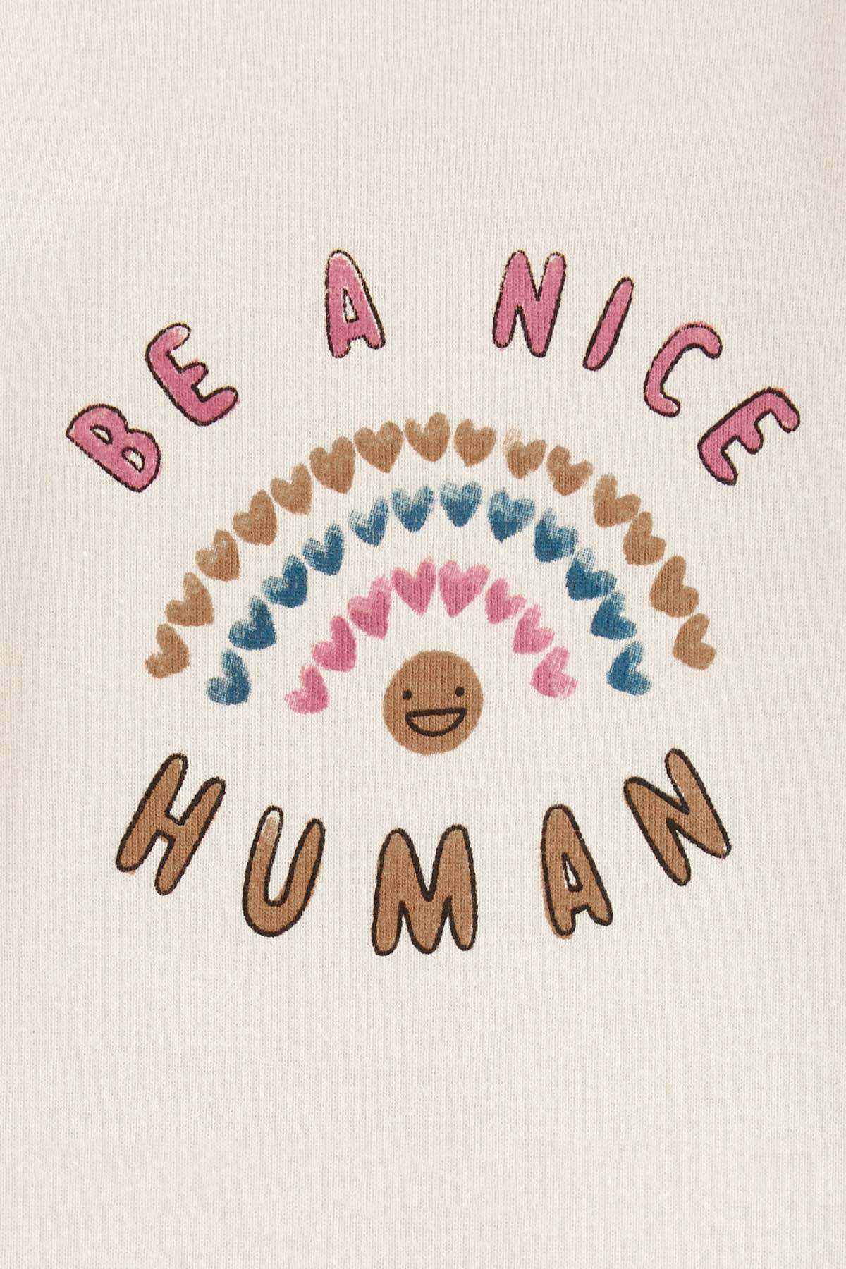 Ivory bodysuit fabric close-up with Be a Nice Human text and rainbow smiley