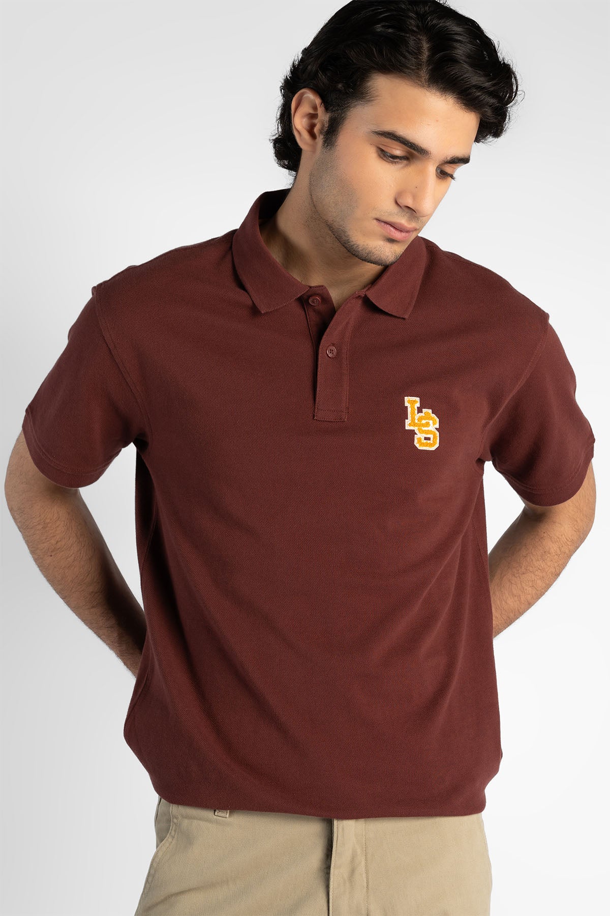 Maroon polo shirt with short sleeves, folded collar, and yellow chest logo