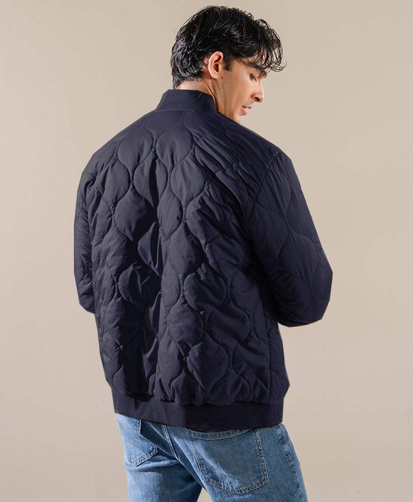 Navy quilted bomber jacket, back view with quilted pattern and yoke