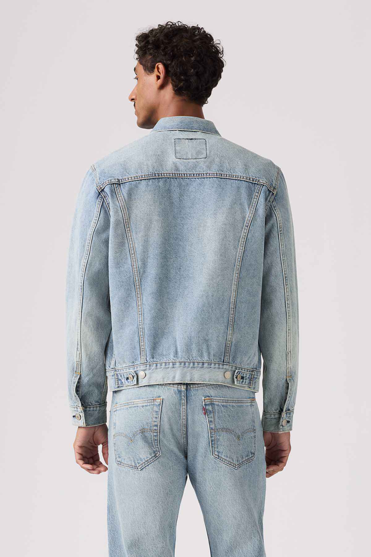 Light indigo denim jacket back view with yoke seam and buttoned cuffs