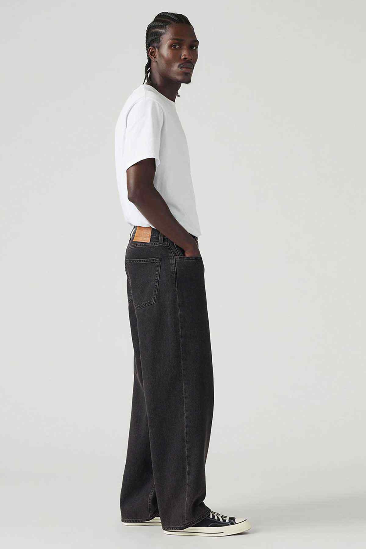 Levi's black denim jeans, side view with wide leg and stitched pockets