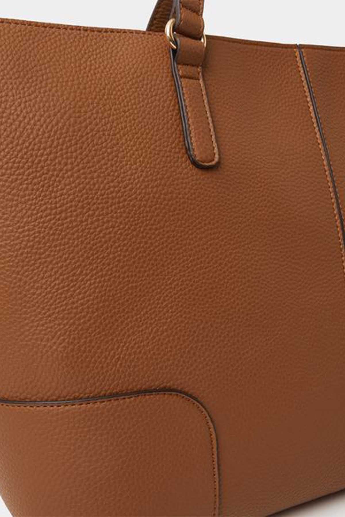 Tan leather-look tote bag close-up of textured surface and handle strap