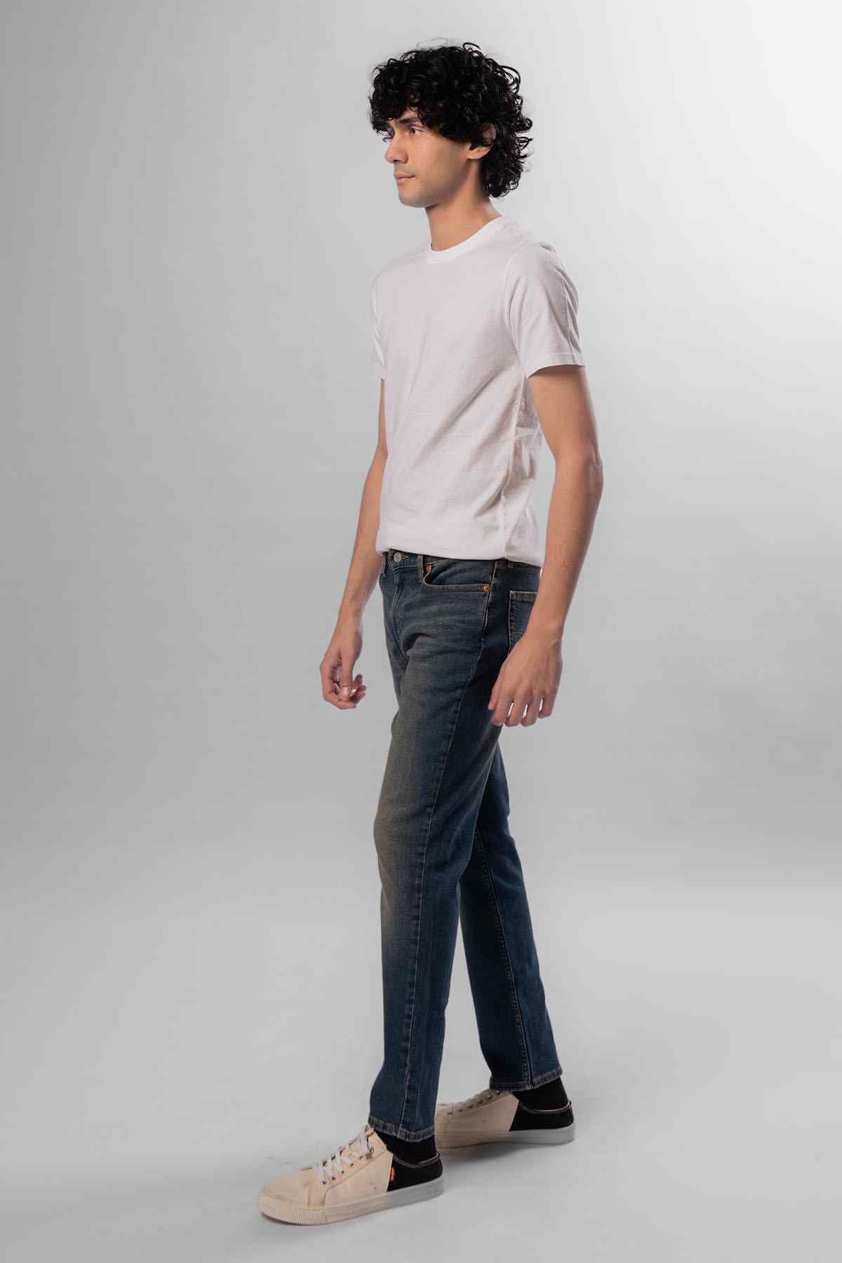 Men's dark blue jeans, side view, straight leg with stitched fly