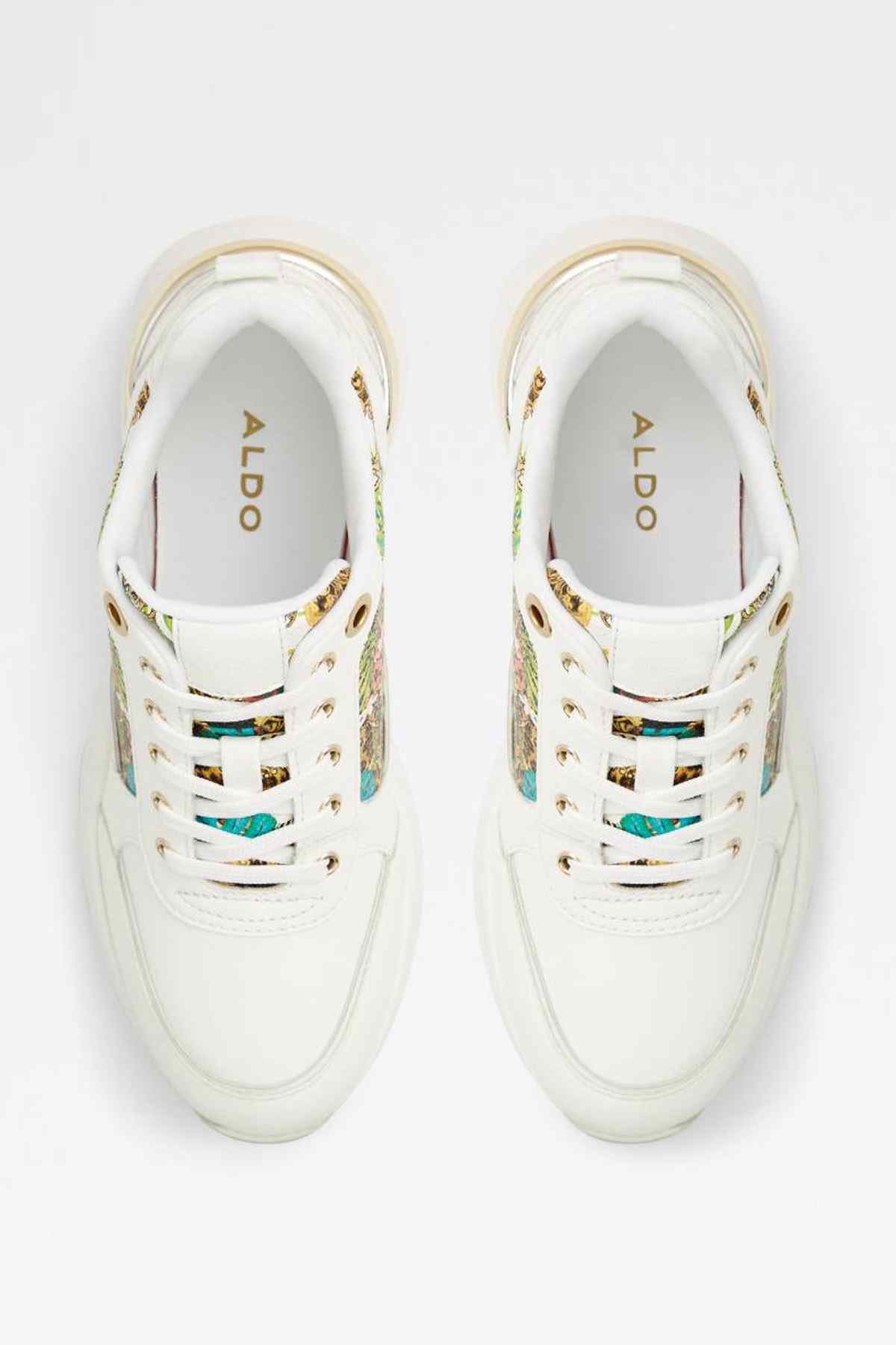 Pair of white lace-up sneakers with multicolor accents and gold eyelet trim