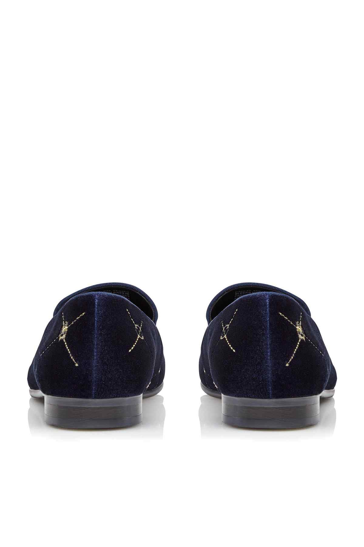 Back view of navy suede slip-on loafer with gold star stitching
