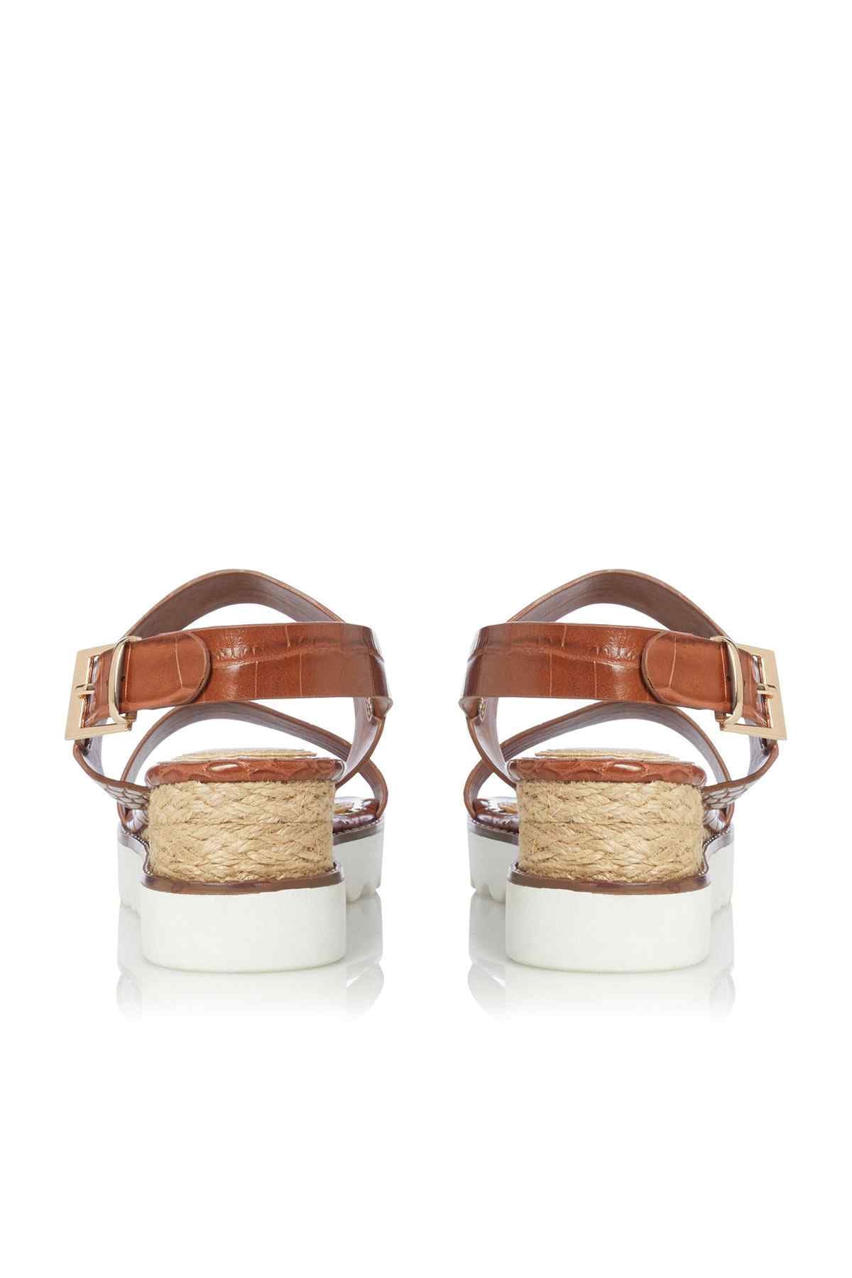 Tan leather sandals with two straps, buckles, and jute-wrapped platform