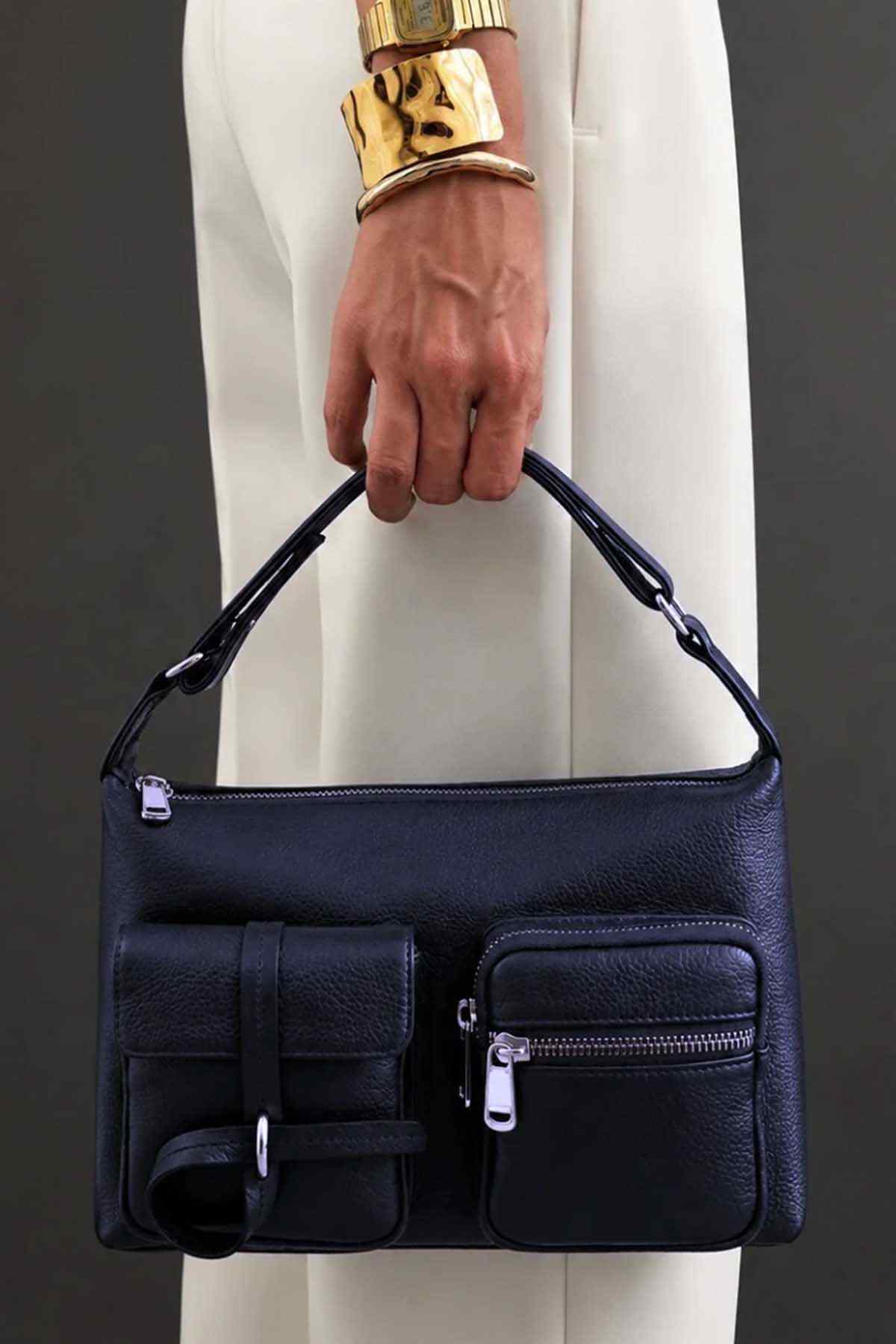 Midnight blue handbag with front flap panel, zip pocket, and top handles
