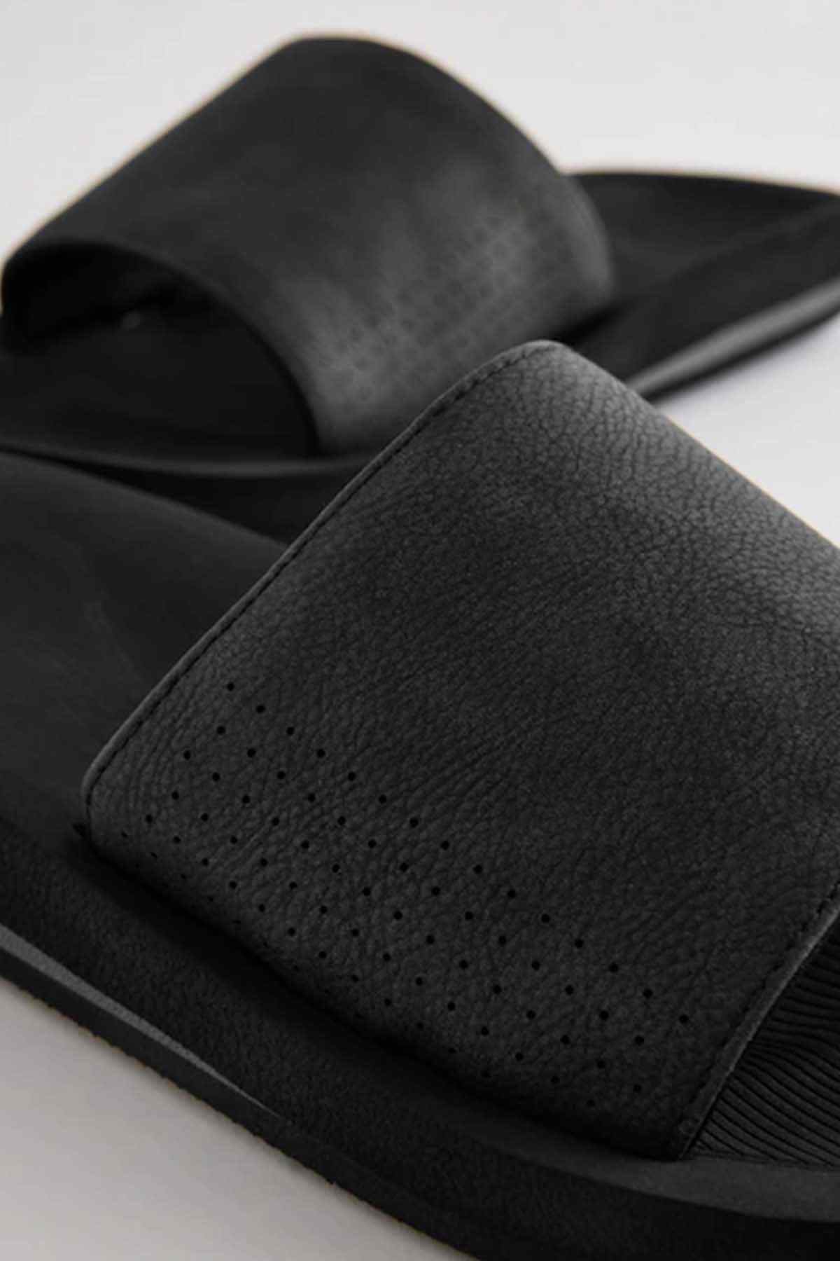 Black slide sandals with grainy strap and perforated front detail