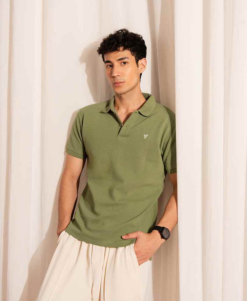 Olive green fitted polo shirt with short sleeves and collar, front view on model