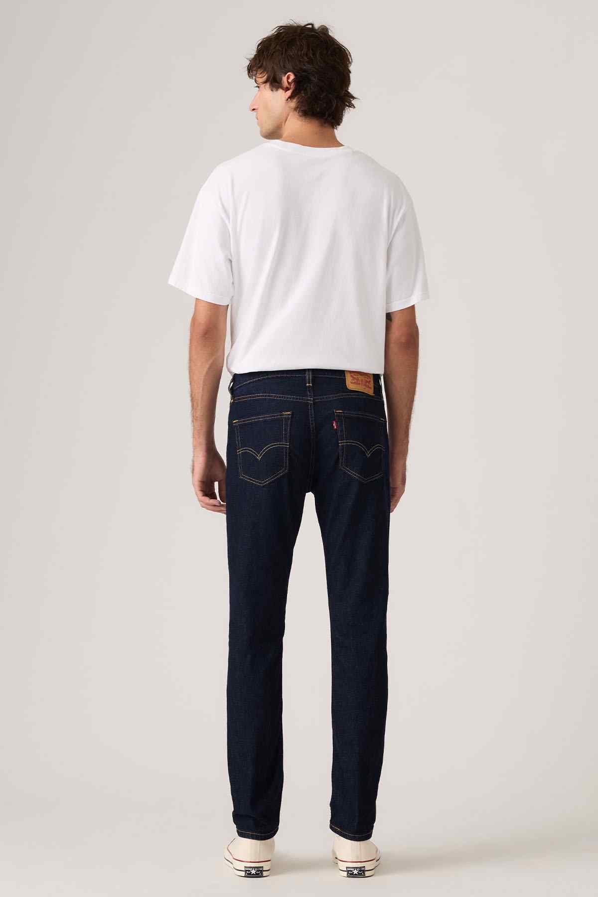 Dark blue denim jeans with straight fit, back patch pockets, and button fly