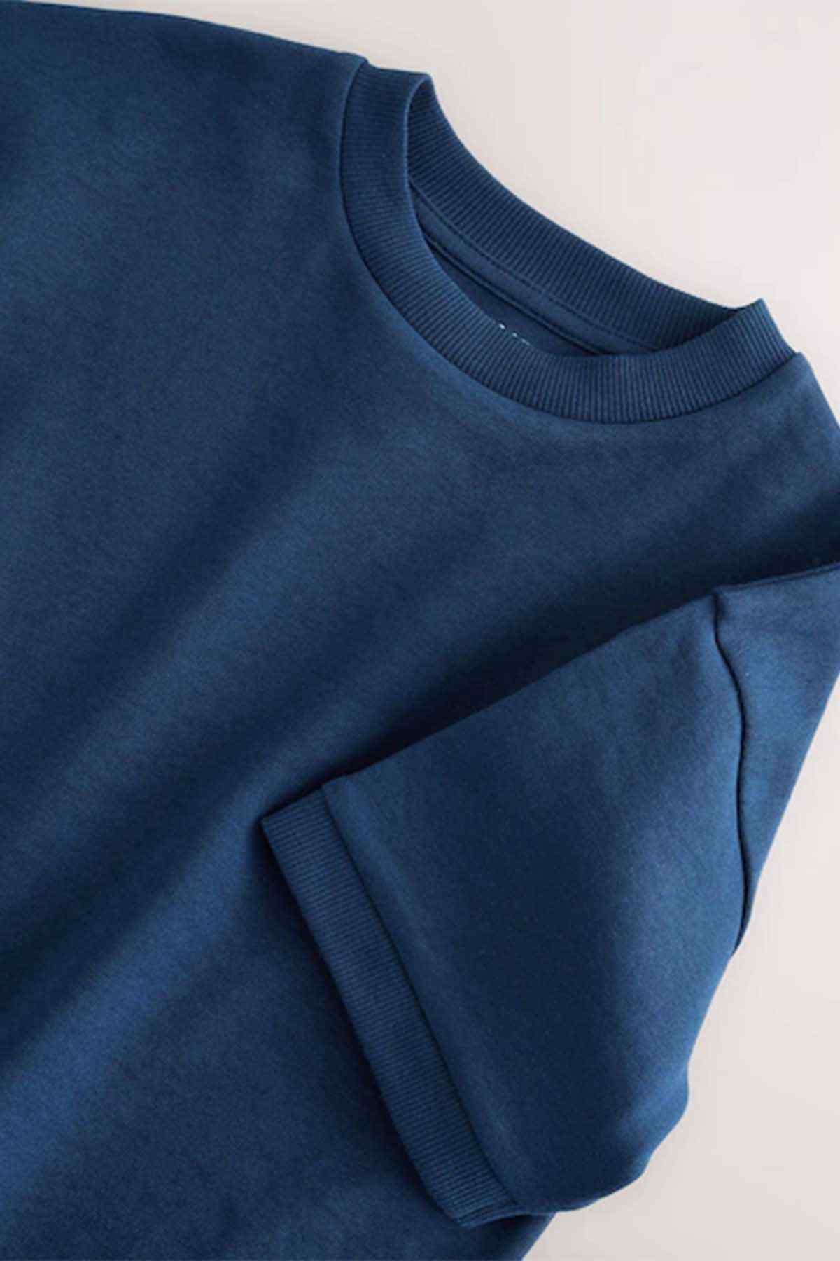 Navy kids T-shirt close-up: crew neck and sleeve cuff, knit texture