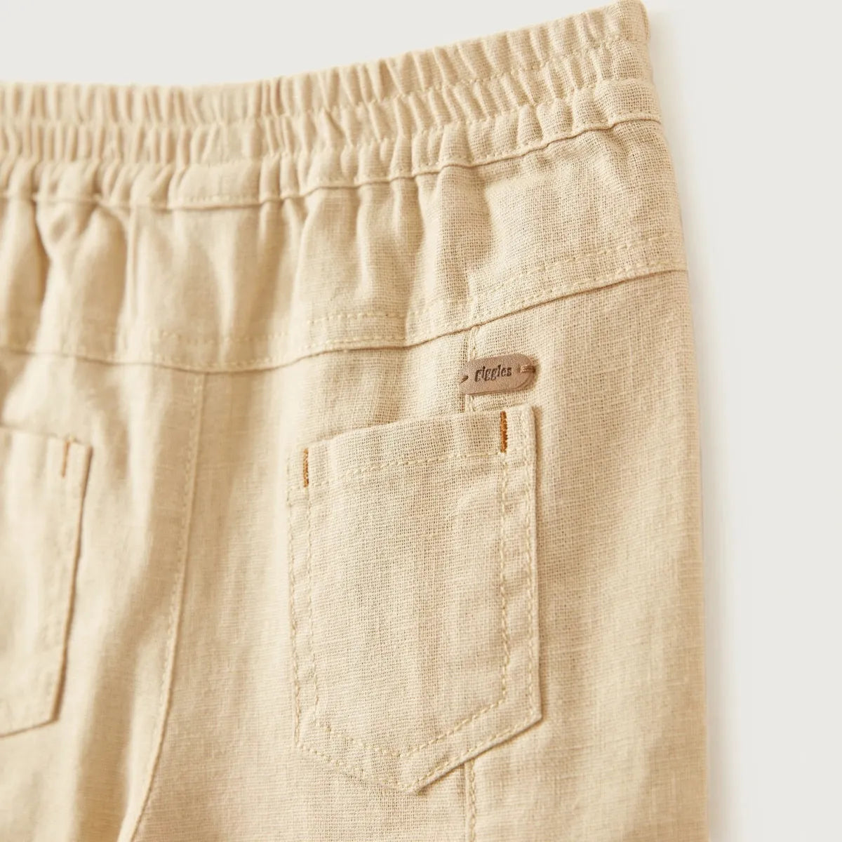 Beige baby trousers detail: back pocket with stitched label and elastic waistband