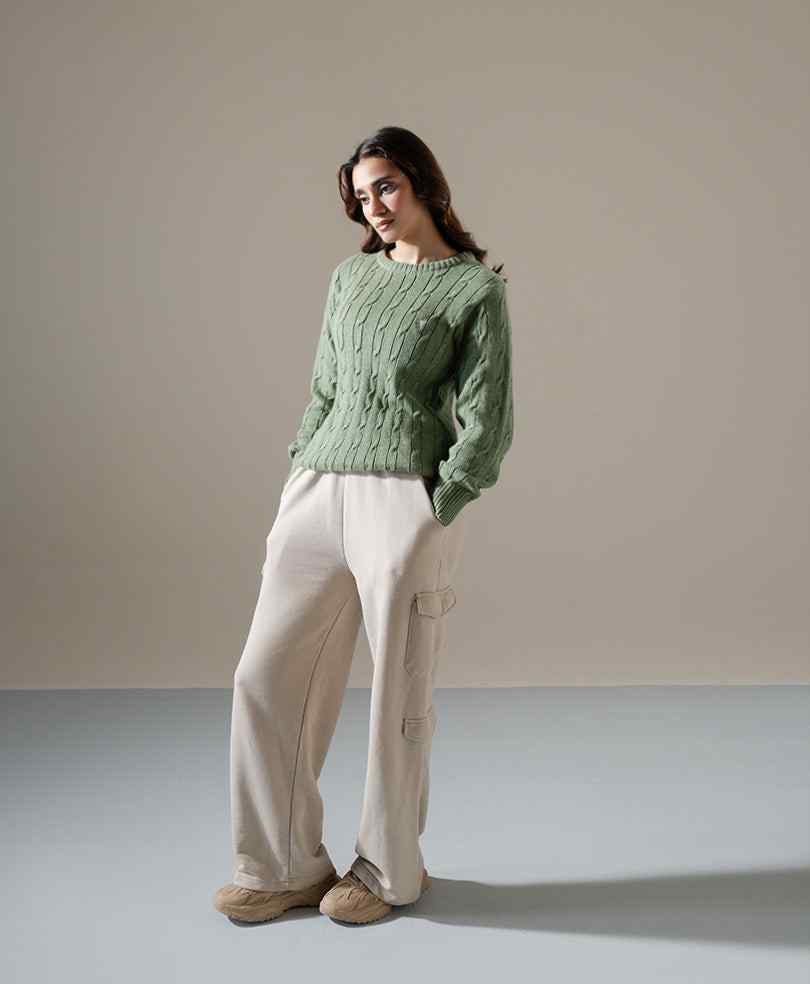 Olive fitted cable-knit sweater with crew neckline and long sleeves, standing pose